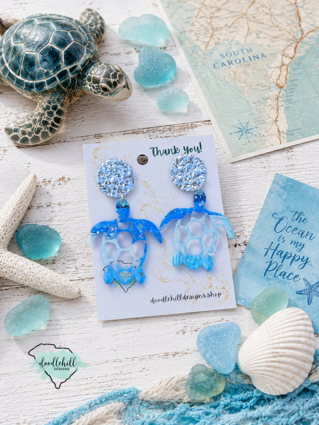 "Handmade sea turtle dangle earrings with watercolor ocean design and silver glitter flakes."
"Coastal sea turtle earrings made from lightweight acrylic with beach-inspired watercolor artwork."
"Beach-themed sea turtle acrylic earrings with sparkling silver glitter accents."
"Watercolor sea turtle earrings for beach lovers and coastal fashion enthusiasts."