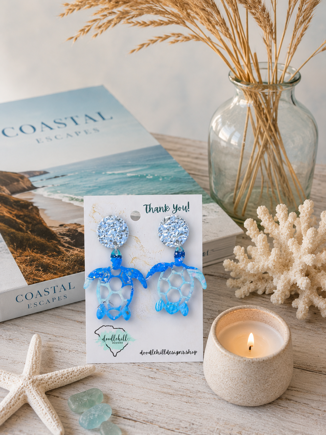 Watercolor sea turtle acrylic earrings with silver glitter accents for beach lovers displayed in a coastal lifestyle setting."