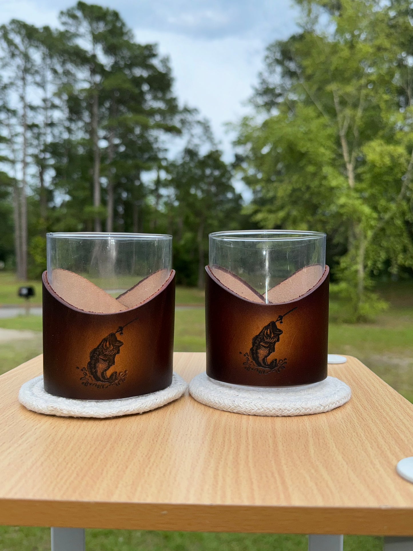 12 oz rocks glass with leather wrap. Wrap has bass jumping out of water engraved on front of leather wrap