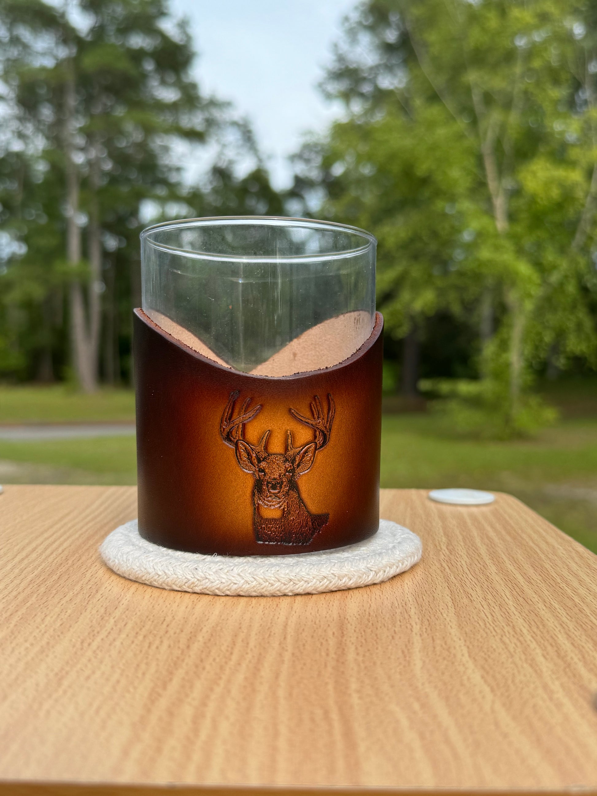 12 oz rocks glass with leather wrap. Wrap has buck head engraved on front of leather wrap