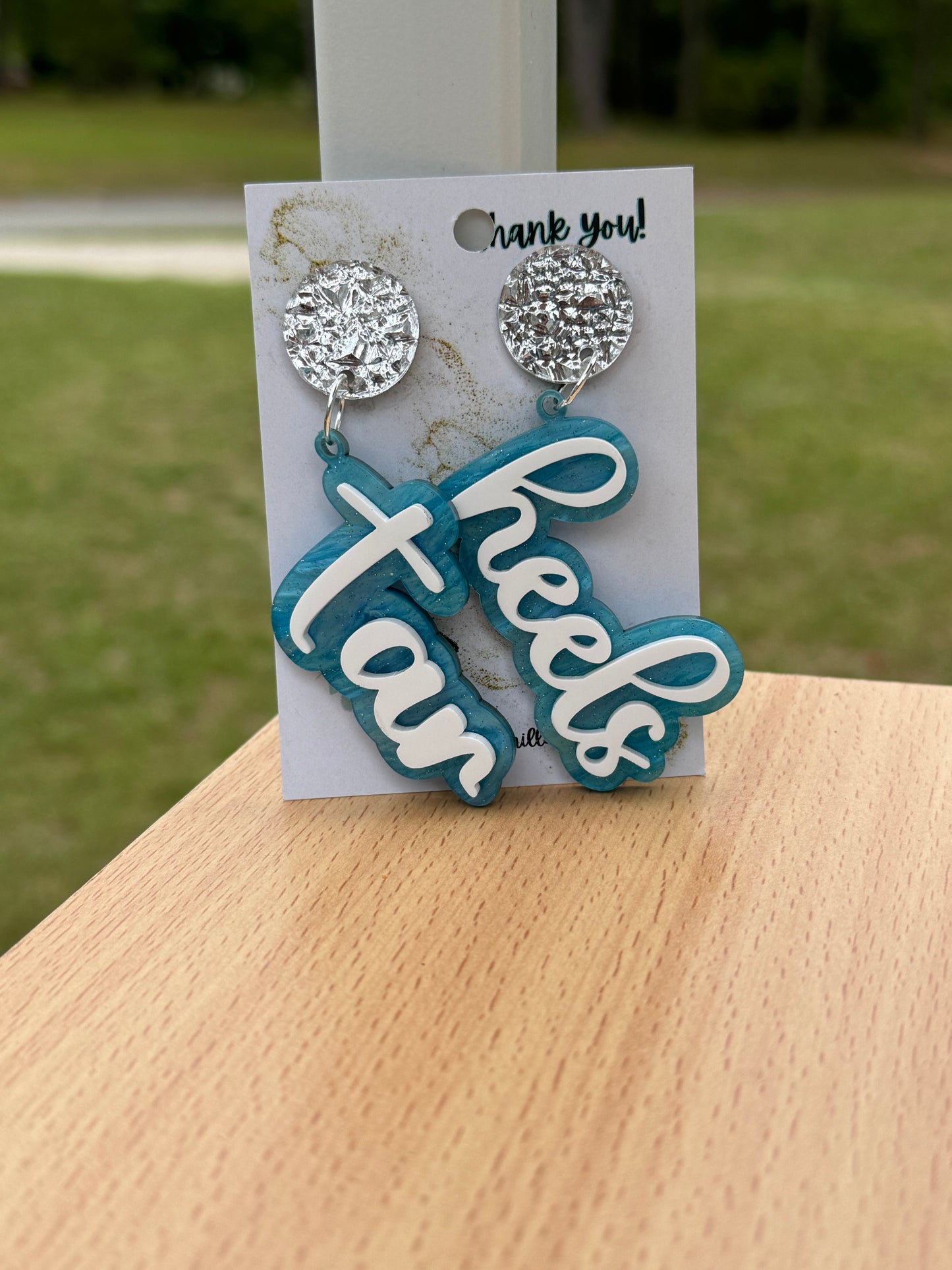 Game day spirit earrings, TAR HEELS earrings are two layers of acrylic  light blue pearlize shimmer and white words acrylic  with silverpost 