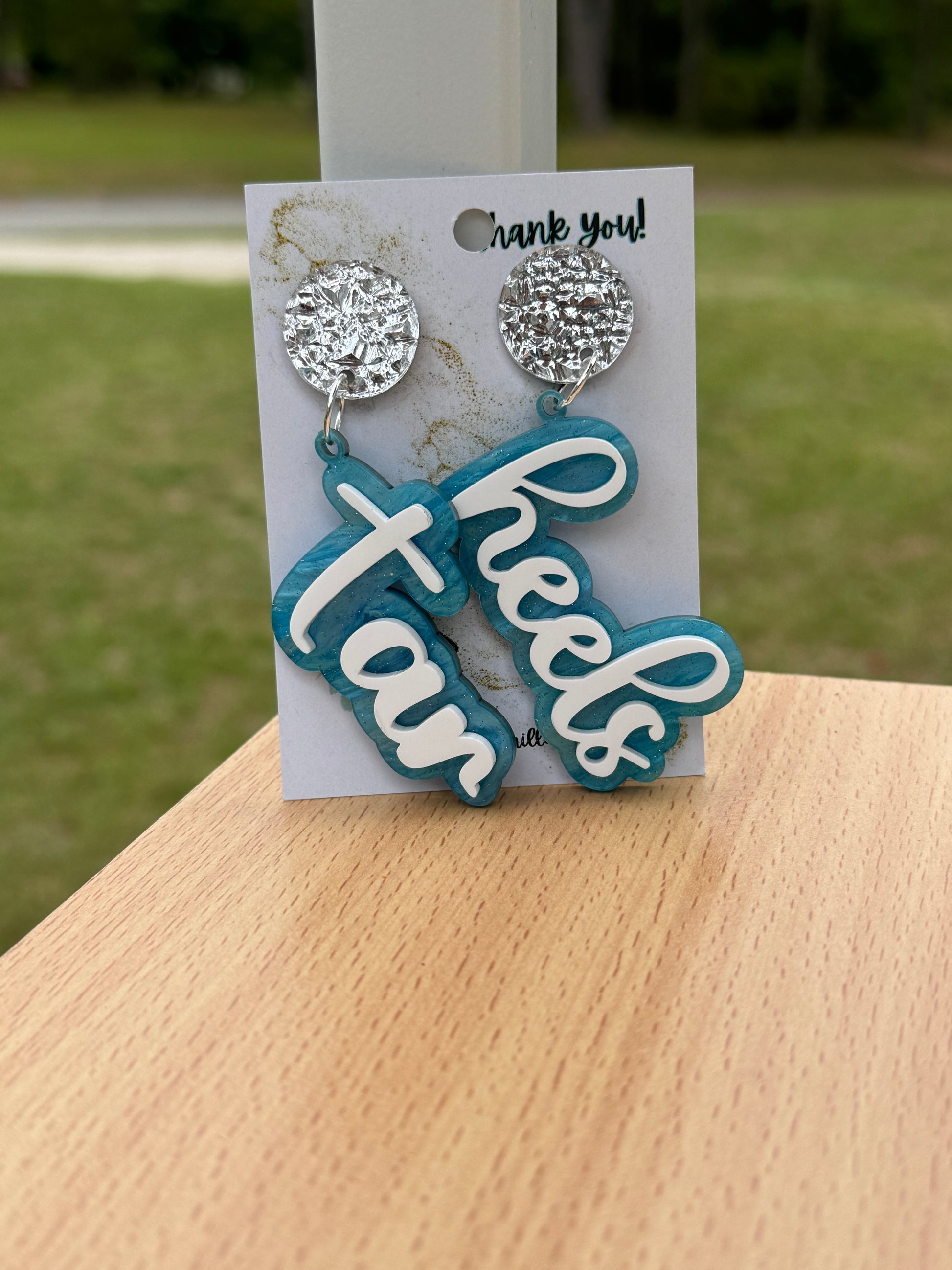 Game day spirit earrings, TAR HEELS earrings are two layers of acrylic  light blue pearlize shimmer and white words acrylic  with silverpost 