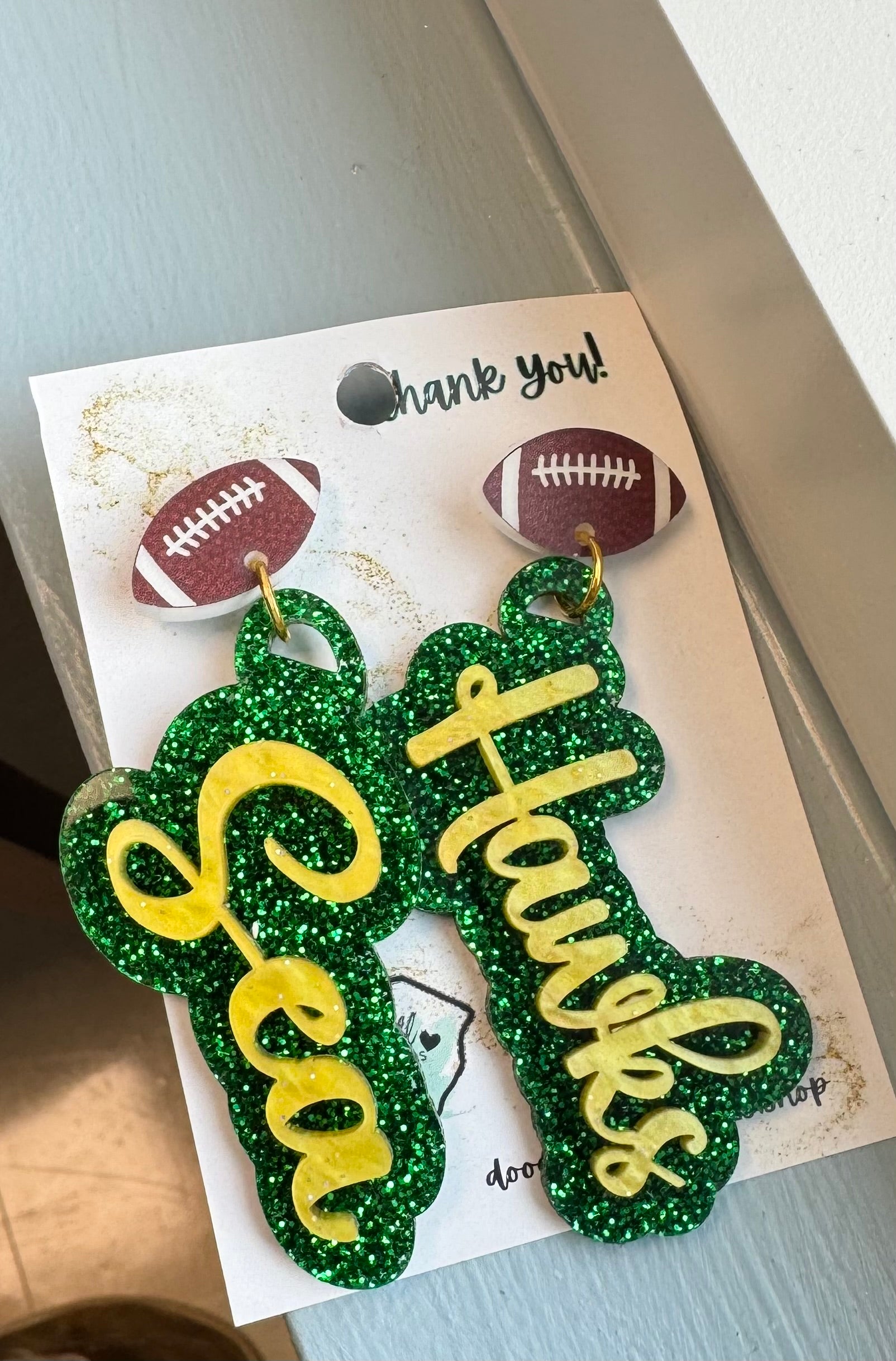 game day two tone acrylic earrings green glitter and gold acrylic Sea Hawk earrings with football post 