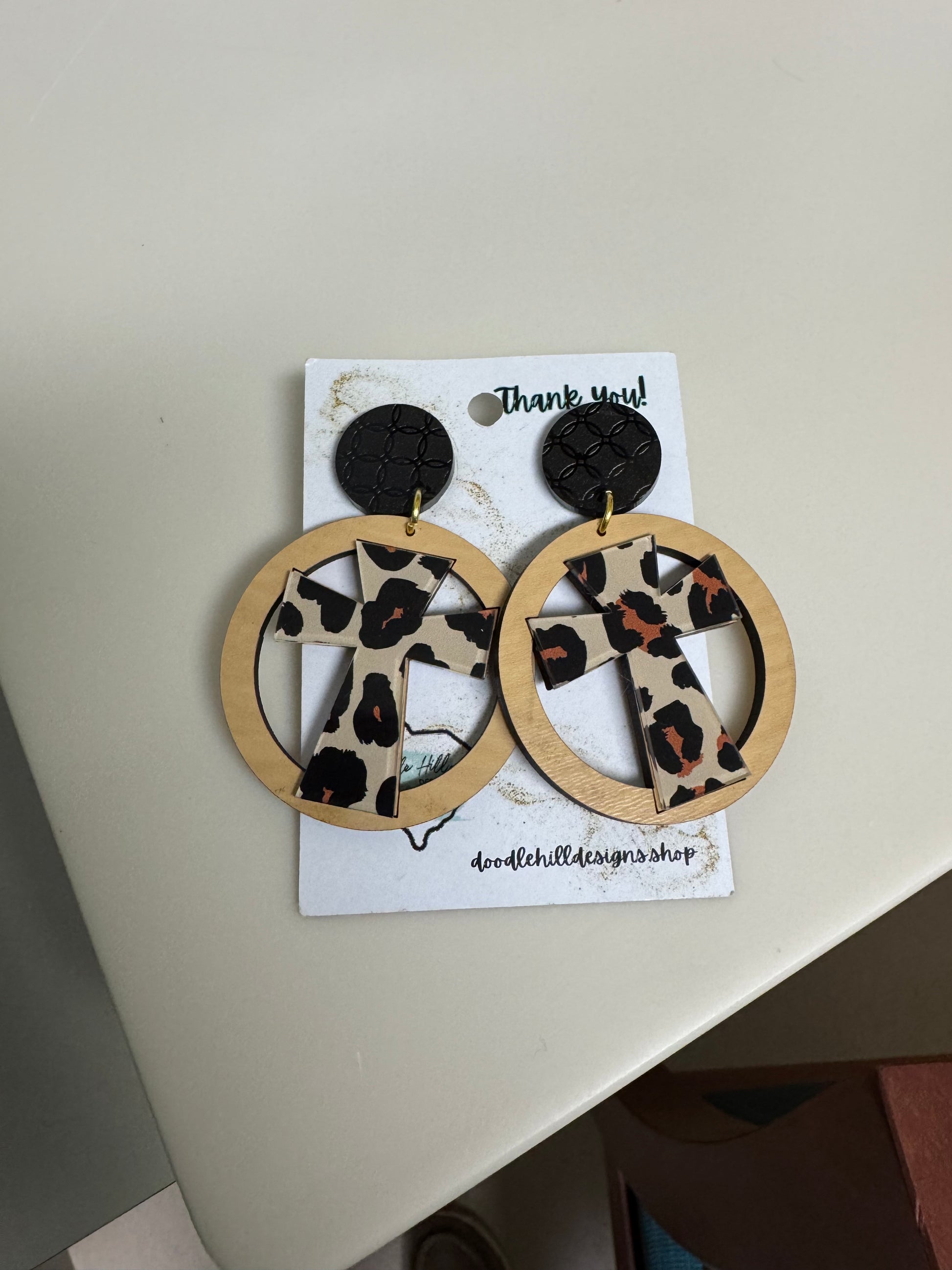 leopard cross earrings with birch circle around. Black textured post 