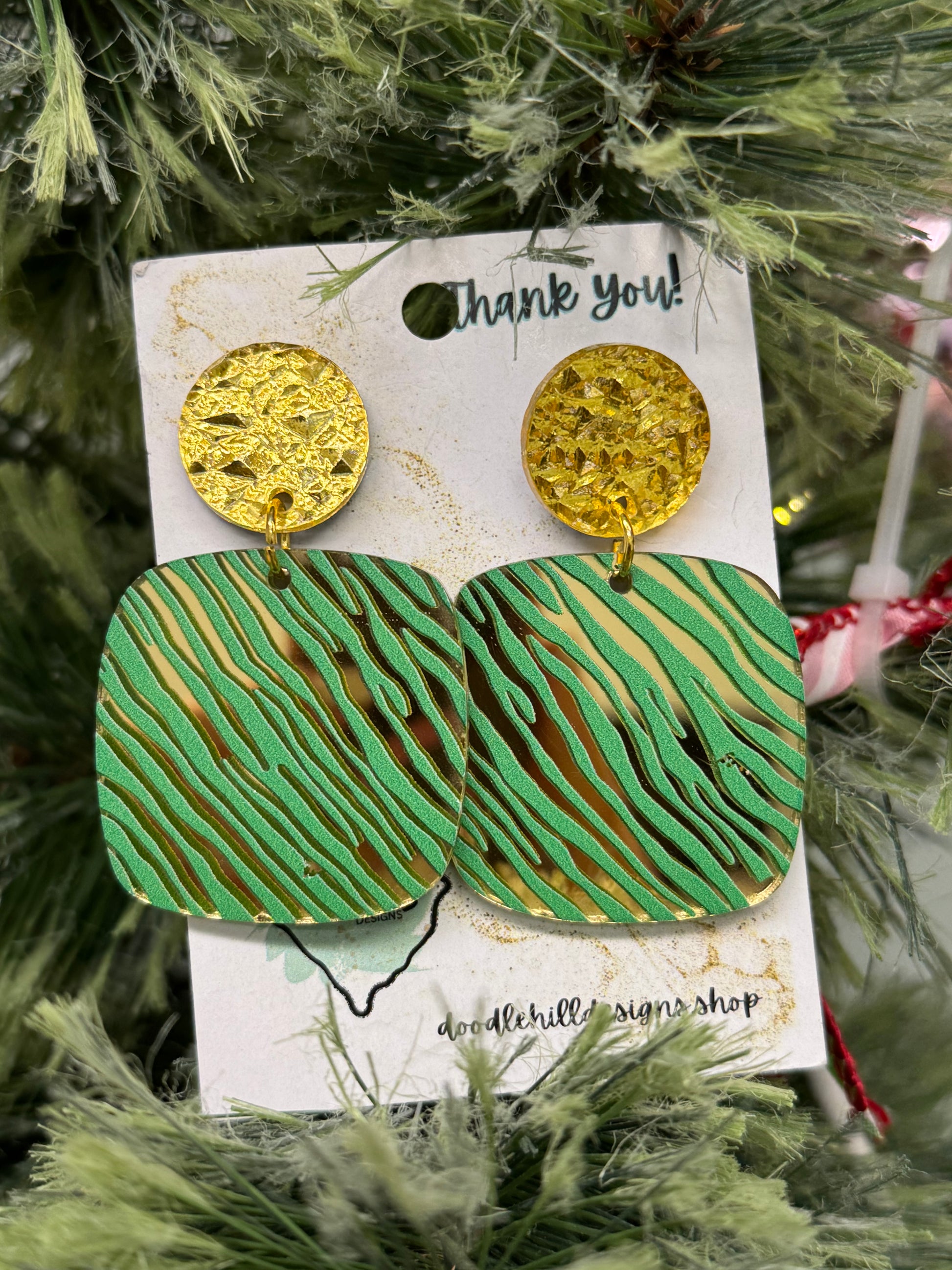 gold mirror earrings with a green zebra print. Post are gold textured