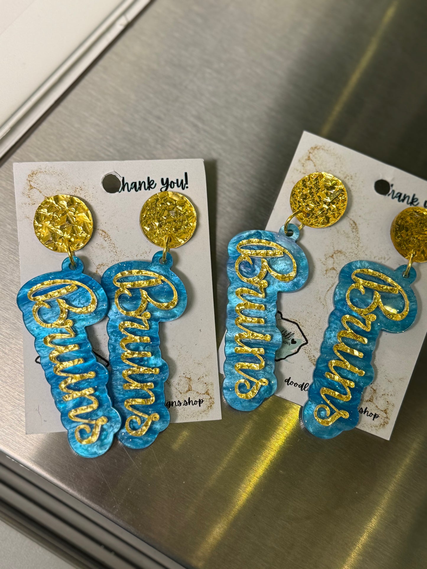 Game day Bruins earrings with gold textured post and blue and gold lettering 