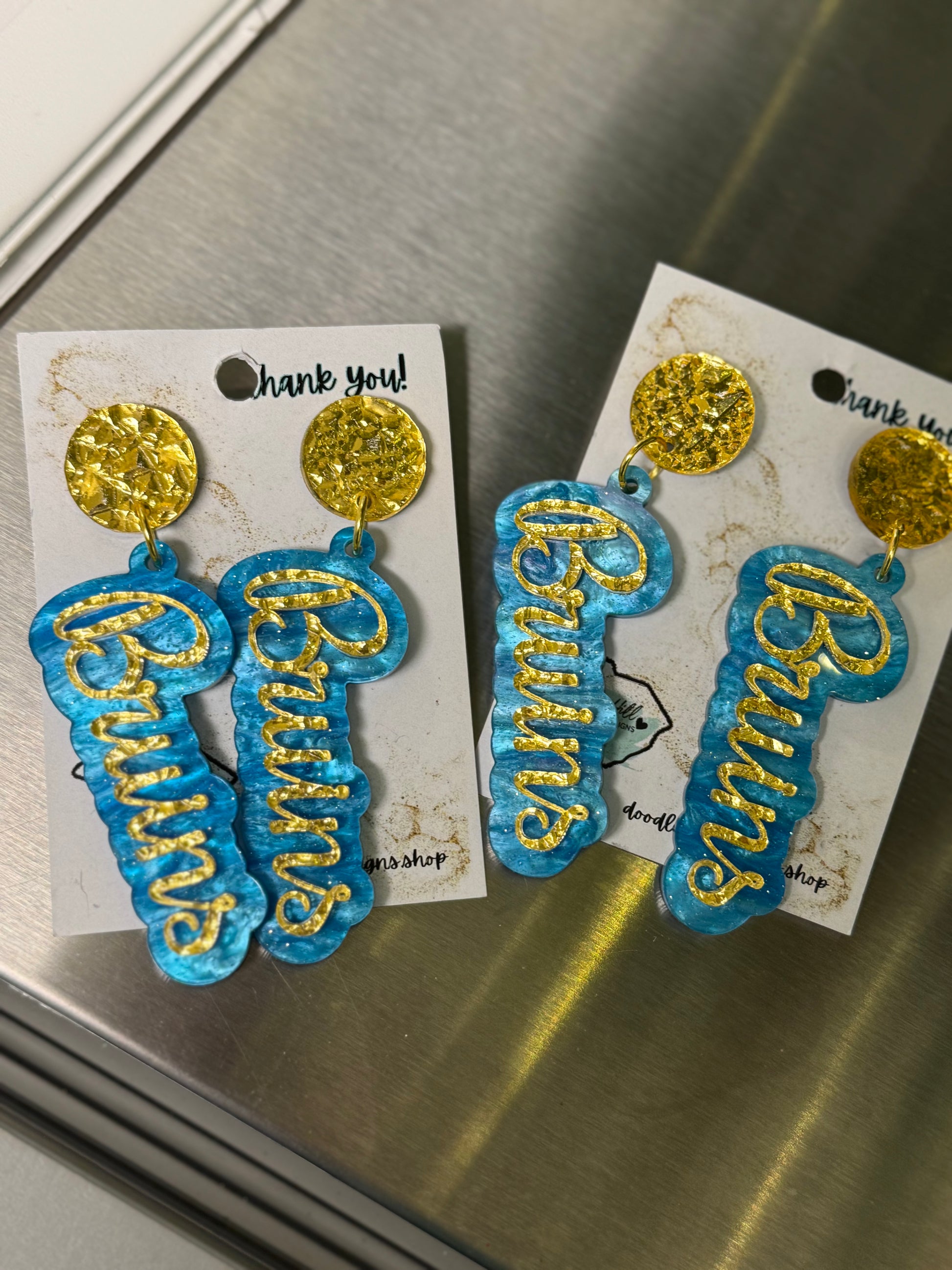 Game day Bruins earrings with gold textured post and blue and gold lettering 