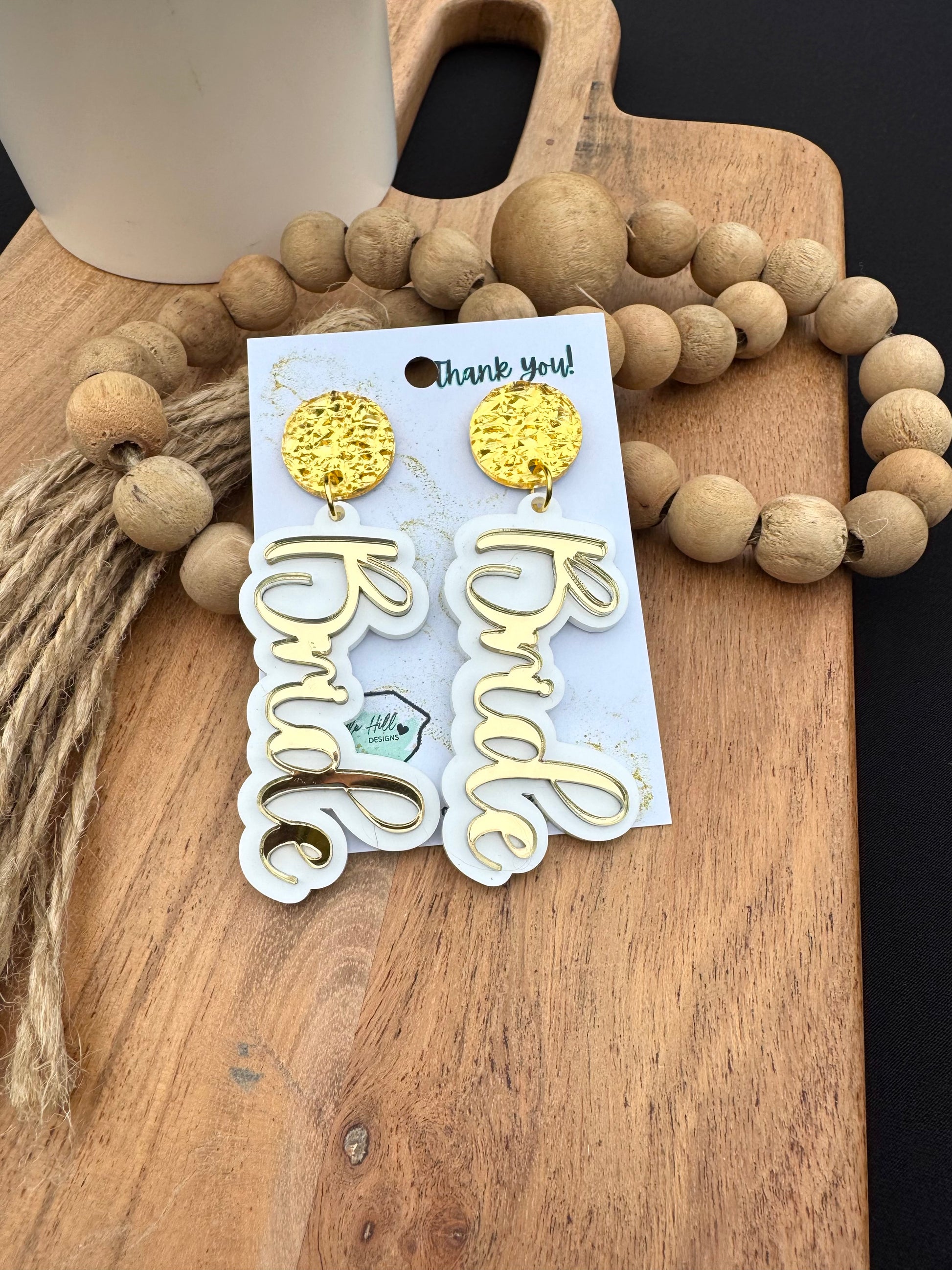 "Bride earrings for bachelorette party – lightweight white acrylic with gold glitter script. Bridal shower jewelry with gold floral posts, perfect wedding gift for bride-to-be. Trendy statement earrings for casual or formal bridal events."
bride earrings, bachelorette party, bridal shower jewelry, wedding gift, statement earrings, gold mirror script