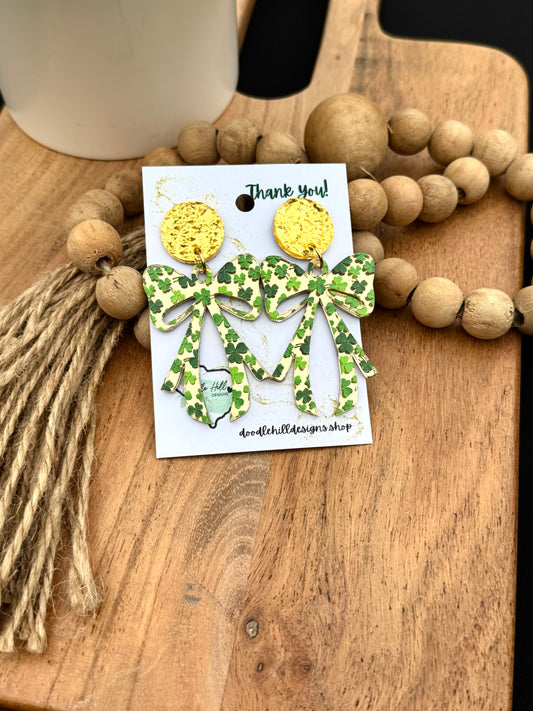 "Shamrock bow earrings for St. Patrick’s Day – lightweight acrylic with green clover print. Festive dangle earrings with gold textured posts, perfect for Irish-themed outfits, lucky charm accessories, and holiday celebrations. Trendy statement earrings for March 17 events and everyday wear."