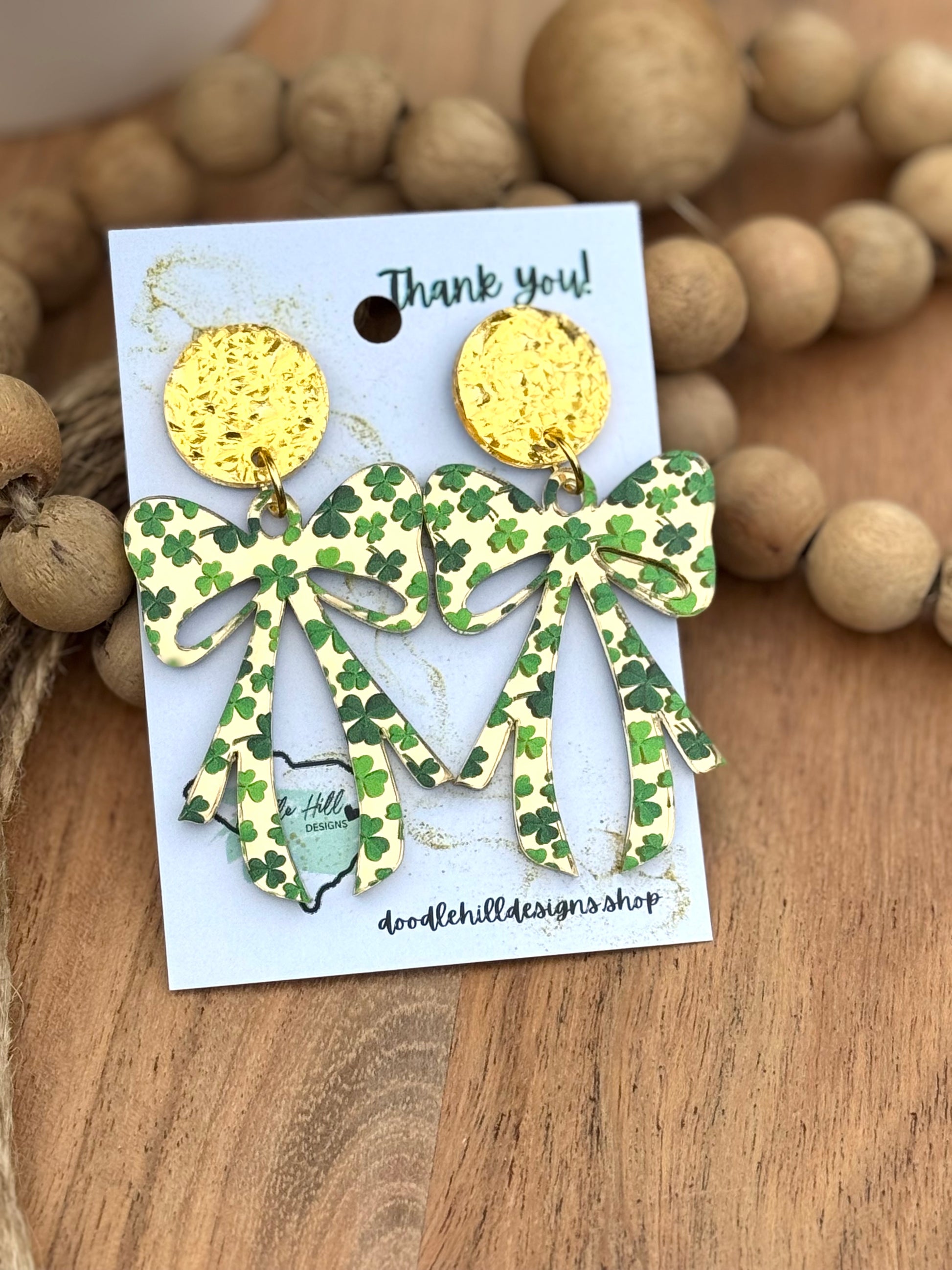 "Shamrock bow earrings for St. Patrick’s Day – lightweight acrylic with green clover print. Festive dangle earrings with gold textured posts, perfect for Irish-themed outfits, lucky charm accessories, and holiday celebrations. Trendy statement earrings for March 17 events and everyday wear."